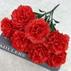 A bouquet of vibrant red silk artificial chrysanthemum flowers displayed on a dark surface.