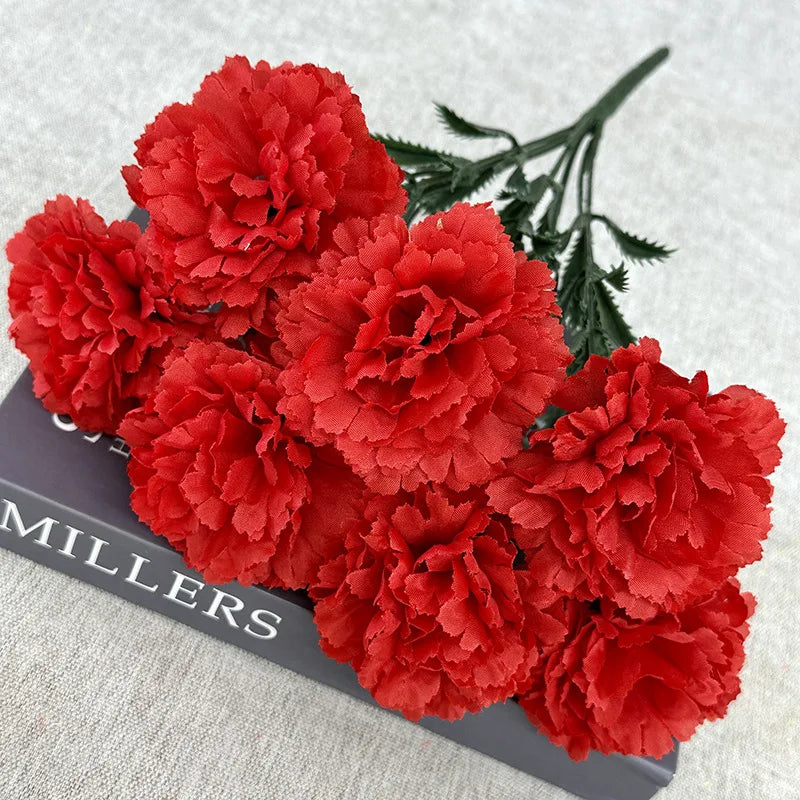 A bouquet of vibrant red silk artificial chrysanthemum flowers displayed on a dark surface.