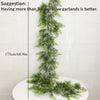 An extra long pine vine wreath used for holiday decor, displayed vertically on a white surface.
