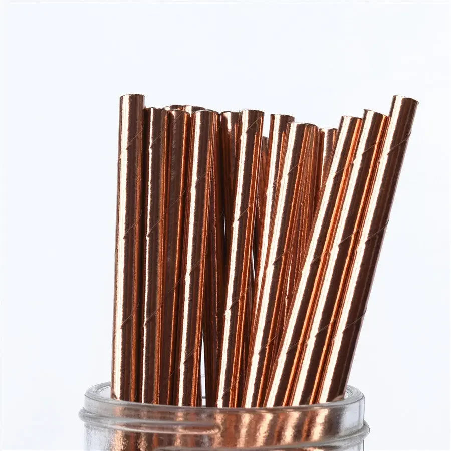 A bundle of brown and gold striped paper drinking straws standing upright in a clear container.