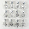 A set of eight decorative glass bottles, each containing a silver figurine and topped with a twist cap.