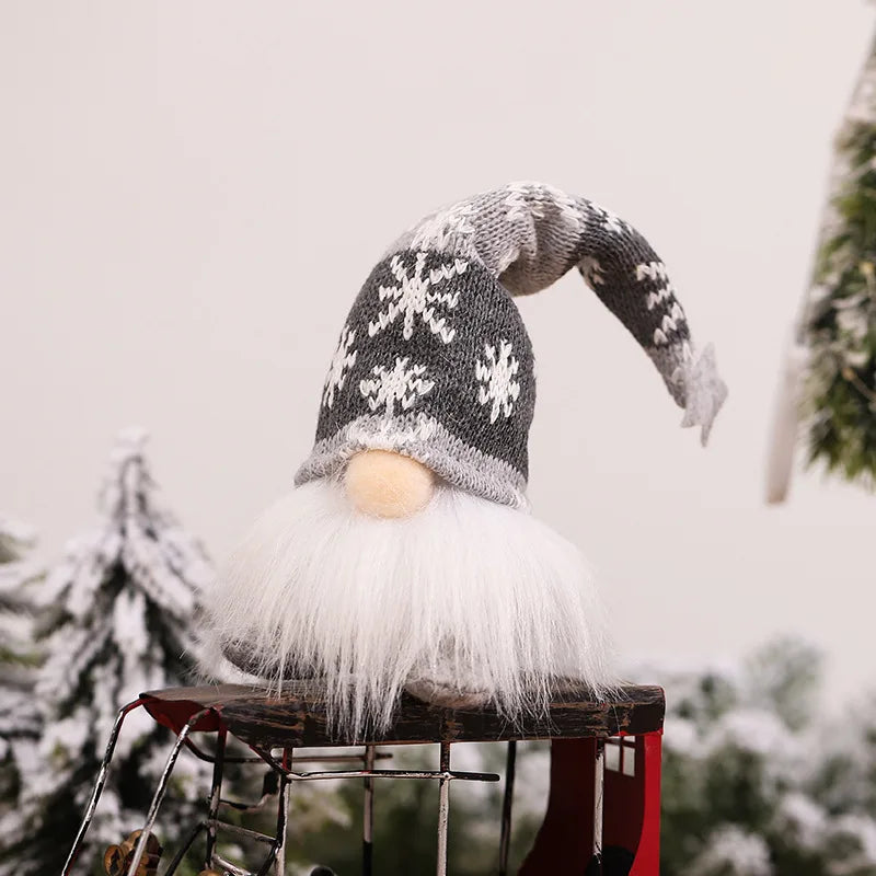 A white and gray knitted gnome decoration with a fluffy white beard and warm glow on a rustic stand.
