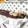 A close-up view of a waterproof oil-proof kitchen wall sticker featuring a white and gray diamond pattern on a cabinet surfac