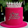 Gâteau rose scintillant décoré d'une couronne en métal et de l'inscription 'Joyeux anniversaire Princesse' en argent.
