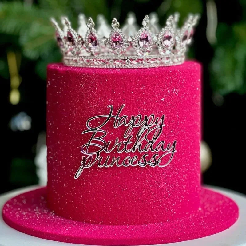Gâteau rose scintillant décoré d'une couronne en métal et de l'inscription 'Joyeux anniversaire Princesse' en argent.