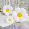 A cluster of white and yellow aluminum foil balloons arranged in a daisy shape against a silver textured background.
