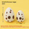 Un juego de dos huevos de dinosaurio pequeños, uno grande y uno pequeño, usados como toppers para pastel.