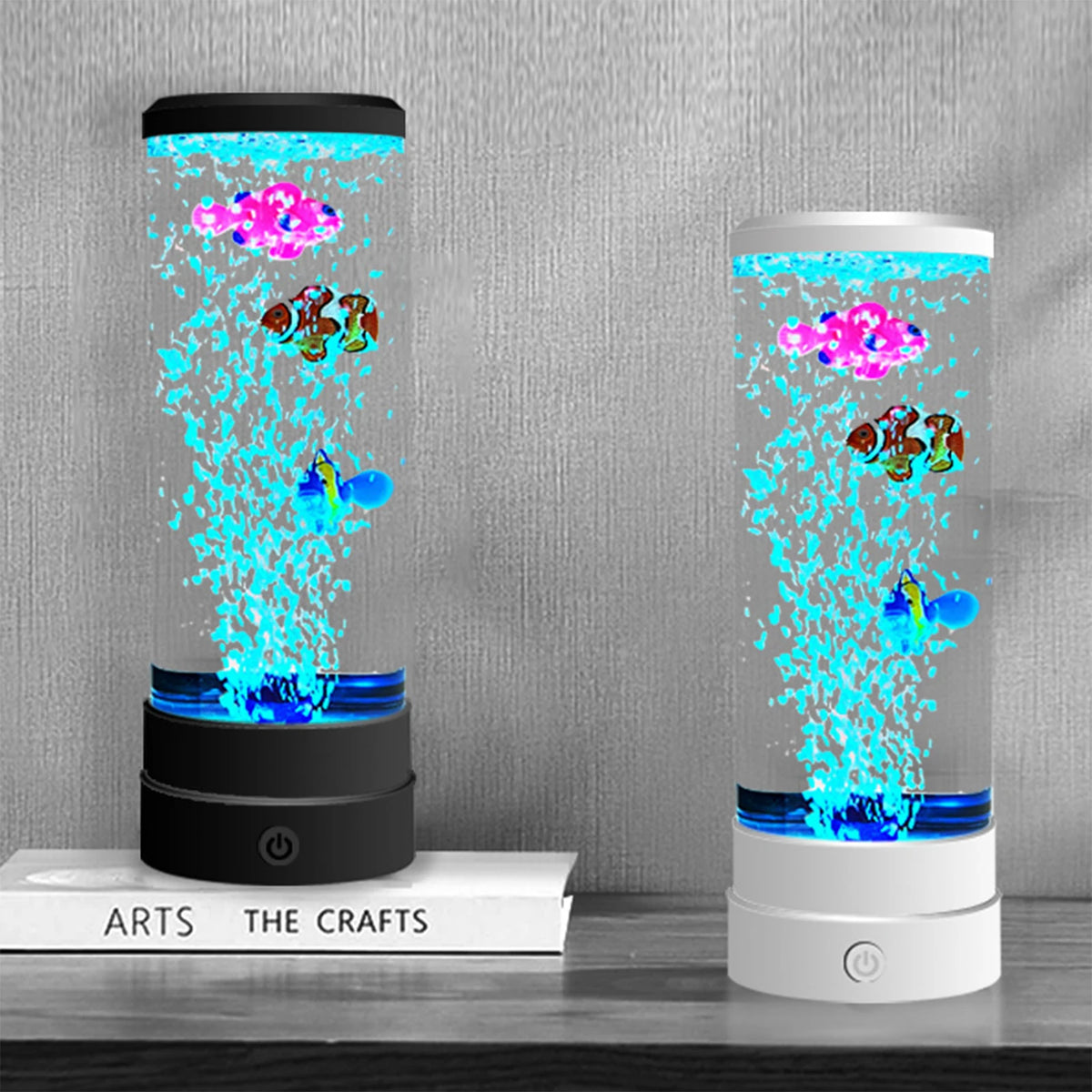 A tall glass lamp displays colorful, glowing fish swimming inside, set on a wooden surface.
