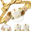 A gold satin ribbon with floral accents and a pearl chain, featuring a Mom to Be corsage pin set.