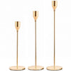 A set of three elegant gold-toned metal candle holders with tall slender stems.