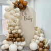 A large arrangement of pastel latex balloons in cream, beige, and gold tones for party decorations.