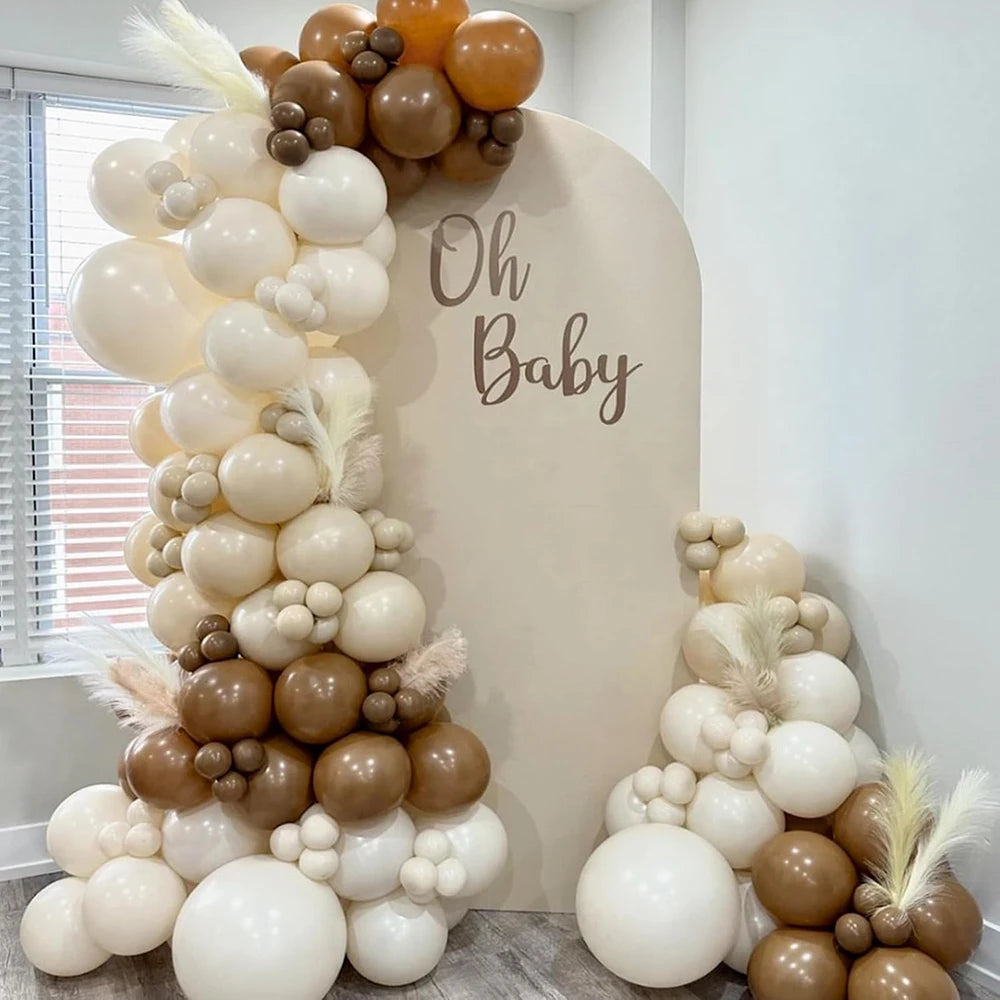 A large arrangement of pastel latex balloons in cream, beige, and gold tones for party decorations.
