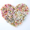 A heart-shaped arrangement of pink, white, and green silk artificial flower heads for decor.