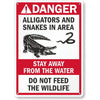 A vintage red and white warning sign featuring an alligator and snake graphic, with text advising to stay away from the water