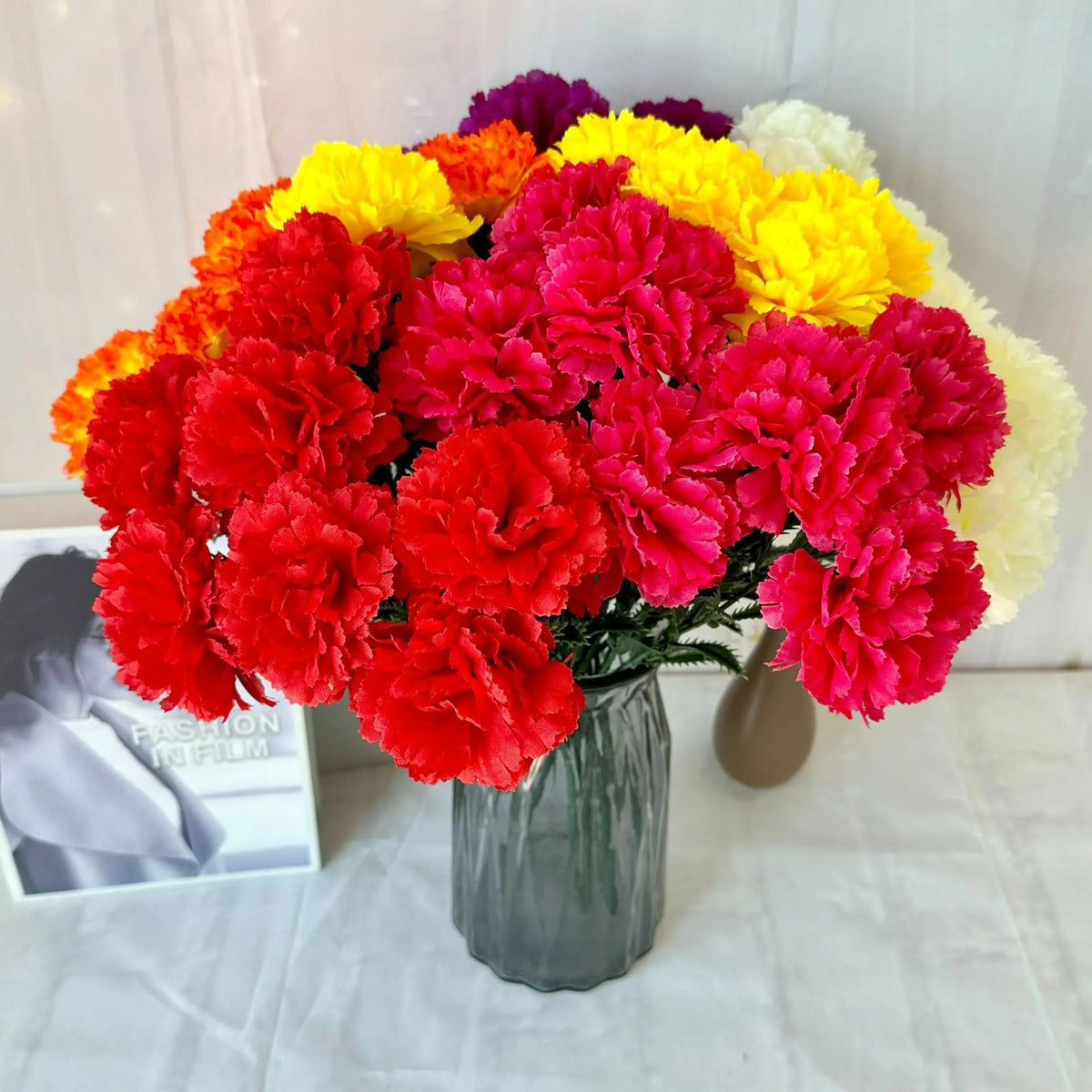 A vibrant bouquet of silk artificial chrysanthemums in shades of red, orange, yellow, and white.