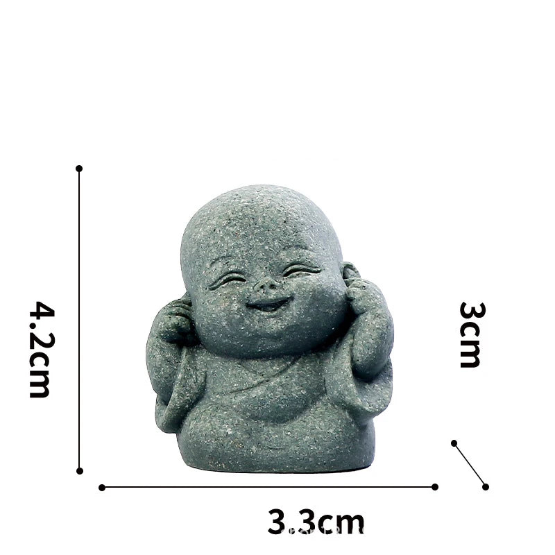 A small, gray stone monk statue used for meditation and Zen decor.
