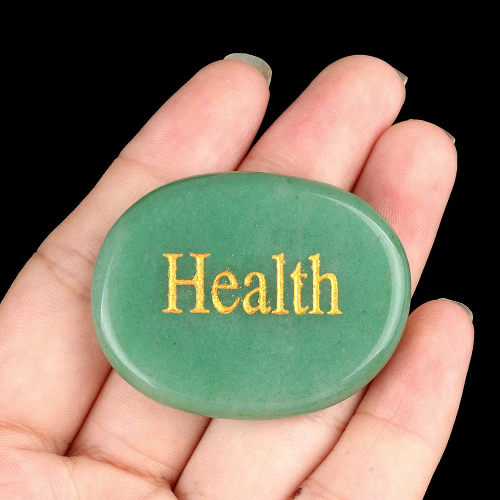 A smooth, oval green crystal is held in a hand against a black background.