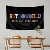 A black tapestry wall hanging featuring the text ASTROWORLD and wish you were here in colorful letters against a starry backg