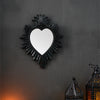 A black wall pendant shaped like a heart with a silver-colored resin finish.