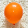 A single, round, bright orange latex balloon resting on a white, fluffy surface.
