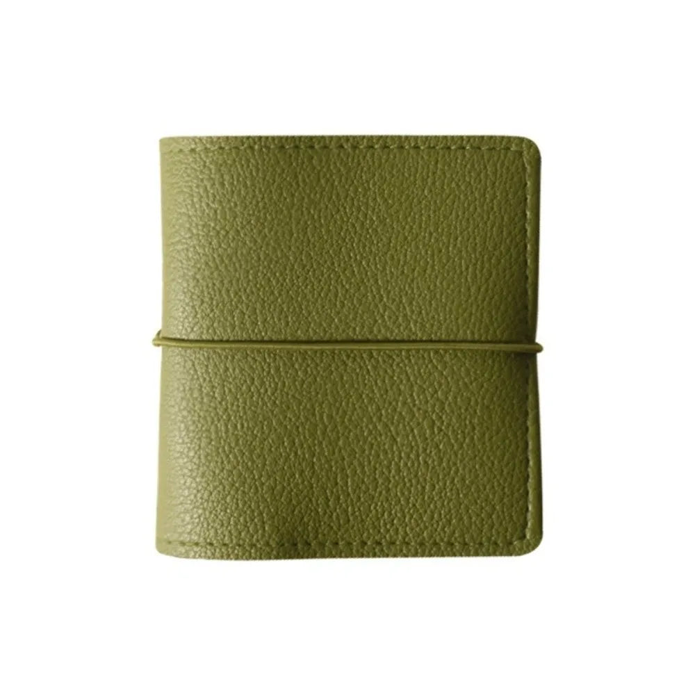 A olive green faux leather photo album with a stitched closure.