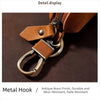 Detail display of a brown leather strap and metal hook used for a key pouch.