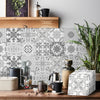 A patterned tile wall sticker design featuring intricate gray and white floral and geometric motifs on a wooden surface.