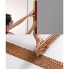 Close-up of brown decorative PE foam edge banding trim being applied to a white wall frame.