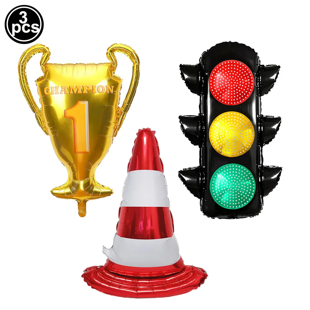 A set of three balloons includes a gold trophy, a black light-up race car number, and a red and white traffic cone.