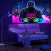 A person wearing a hoodie is intensely playing a video game with colorful lights, set against a backdrop of a city skyline.