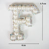 Alphabet letter F made of white pearls and rhinestones on a clear patch