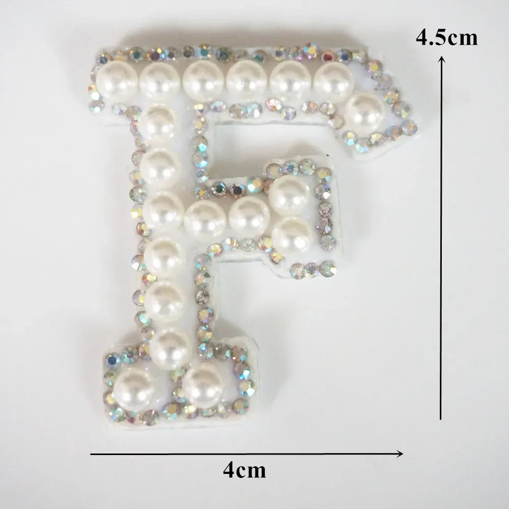 Alphabet letter F made of white pearls and rhinestones on a clear patch