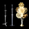 A set of reusable balloon display stands with clear plastic stems and gold-colored balloons.