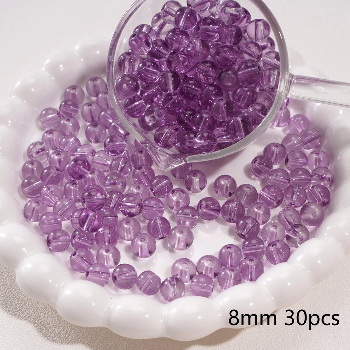 A small glass bowl filled with purple round spacer beads for jewelry making