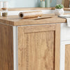 A roll of self-adhesive wood grain wallpaper is placed on a wooden countertop next to a white cabinet.