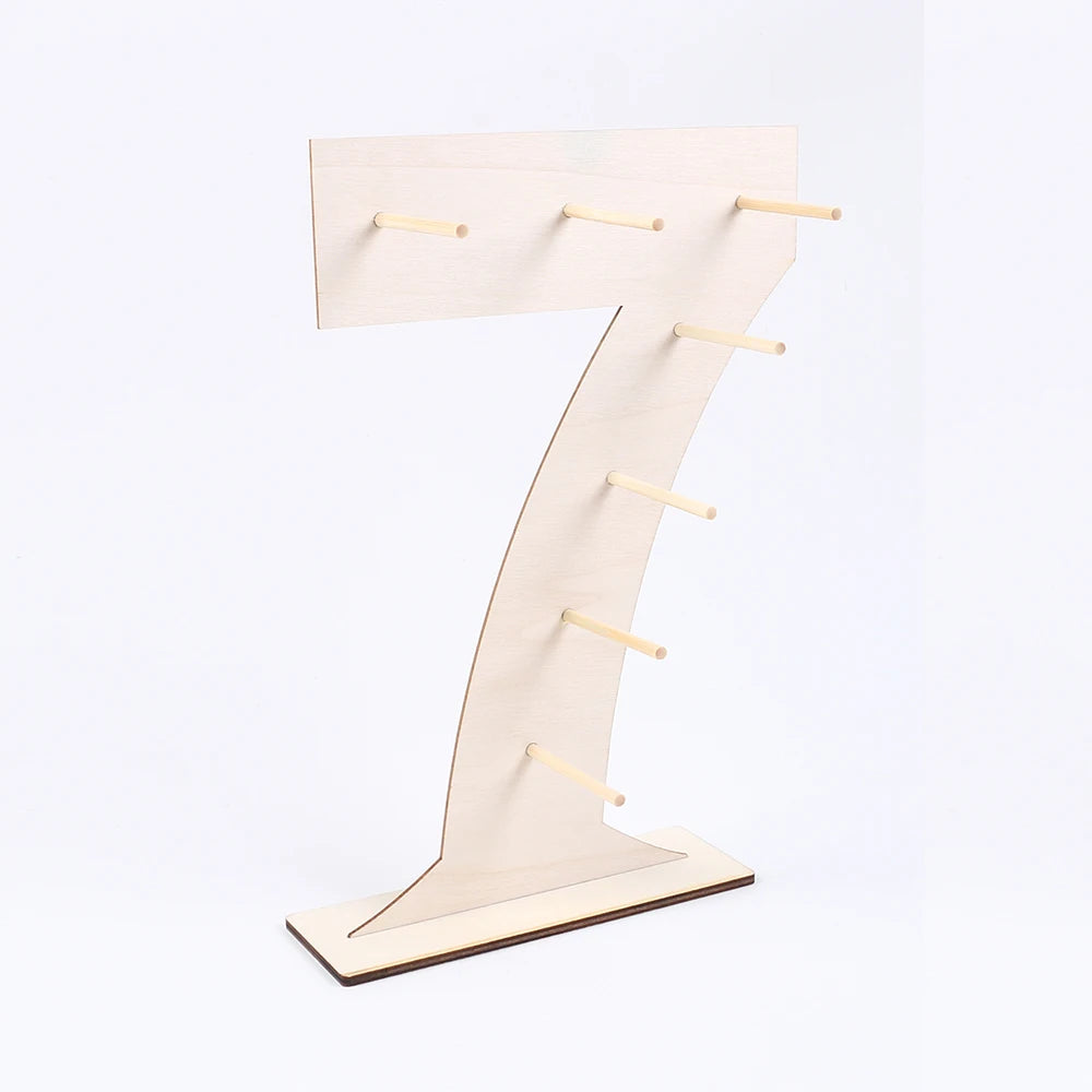 A light wood number display stand shaped like the numeral seven, used for serving desserts.