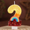 A golden sequined number 9 and a rainbow sequined cake topper on a white stand.