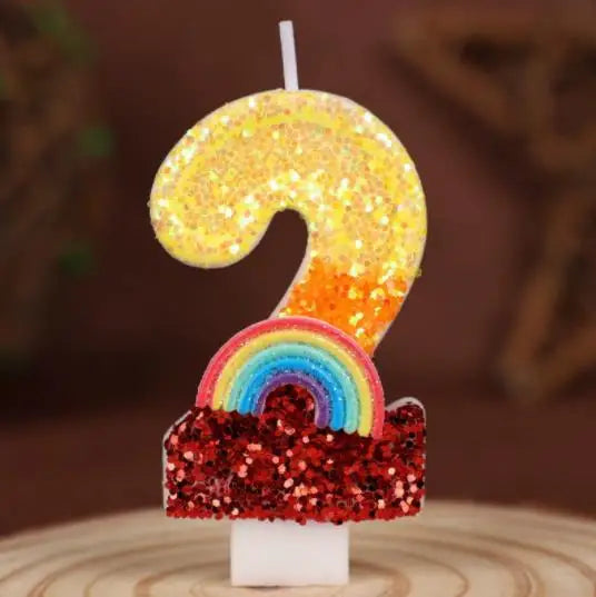 A golden sequined number 9 and a rainbow sequined cake topper on a white stand.