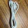 A white rechargeable wearable cooling fan with a clip-on connector and coiled cord lying on a wooden surface.