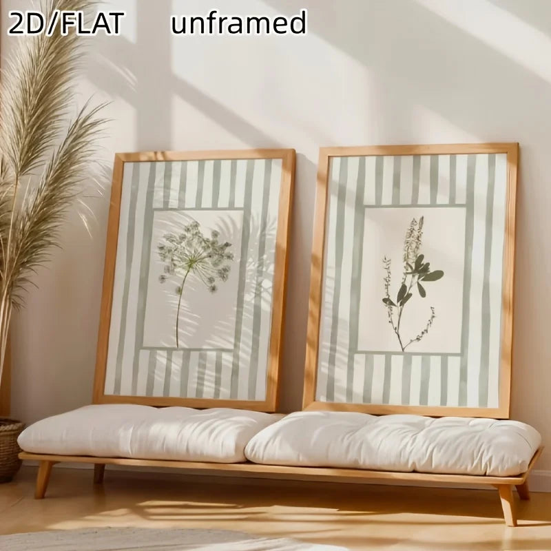 A set of two unframed canvas prints featuring sage green floral designs displayed on a wooden bench.