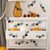 A white cabinet display featuring various orange and white pumpkins and black bat wall decals.