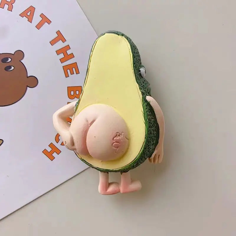 A cute 3D fruit fridge magnet featuring an avocado with a pink, round body and green skin.