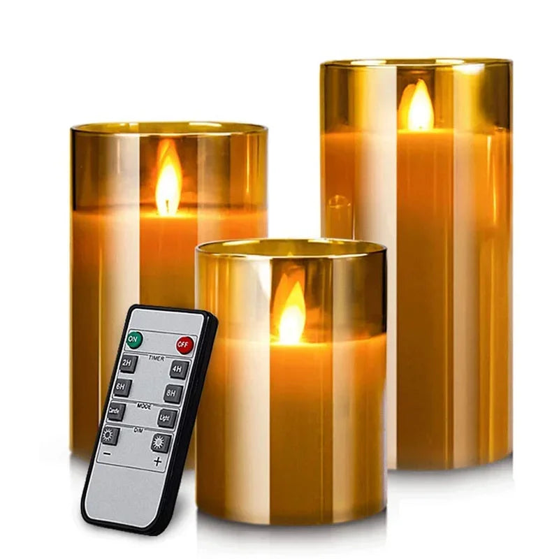 A set of tall, cylindrical glass pillar candles with flickering flames and a remote timer.