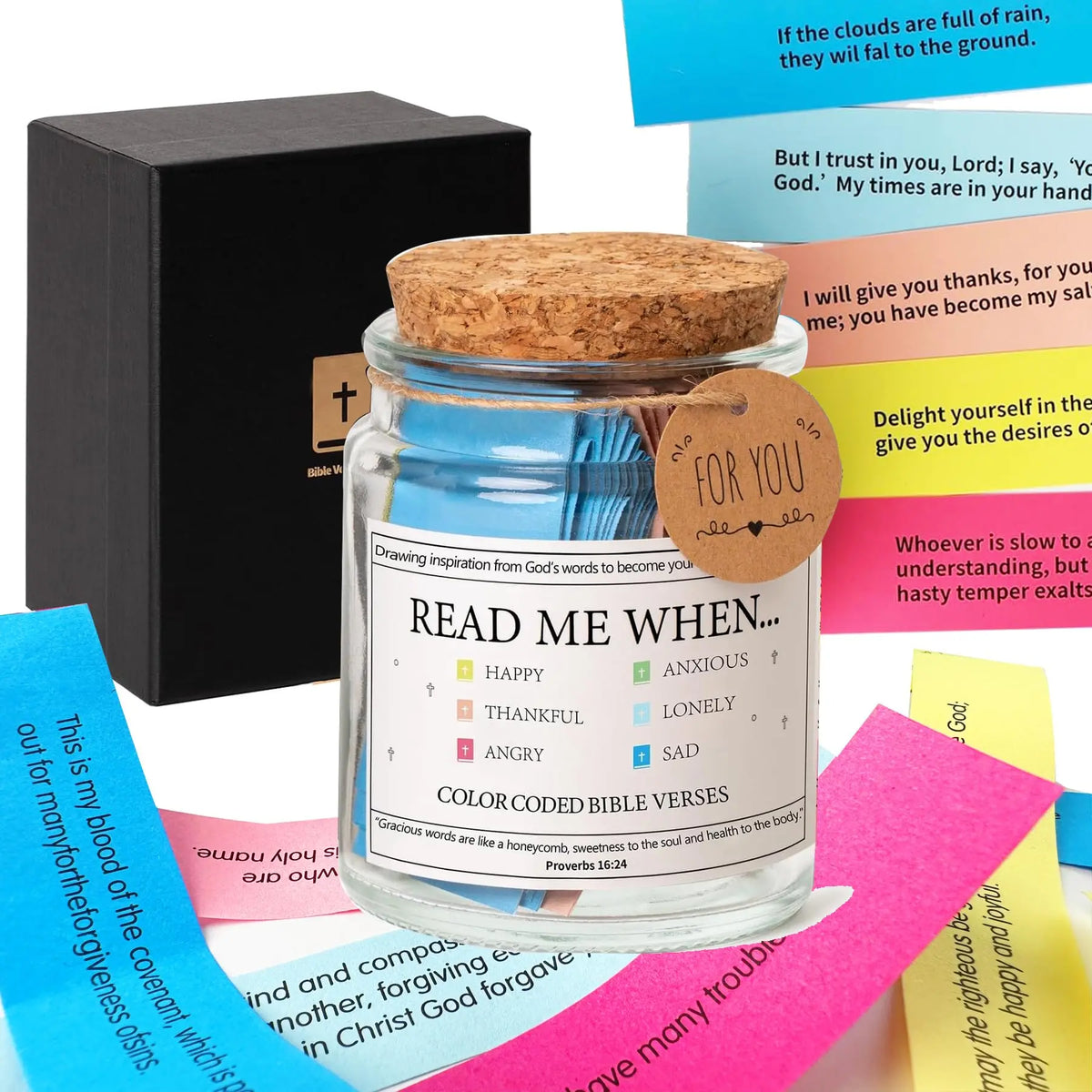 A glass jar filled with colored Bible verses for prayer and comfort next to a dark box.