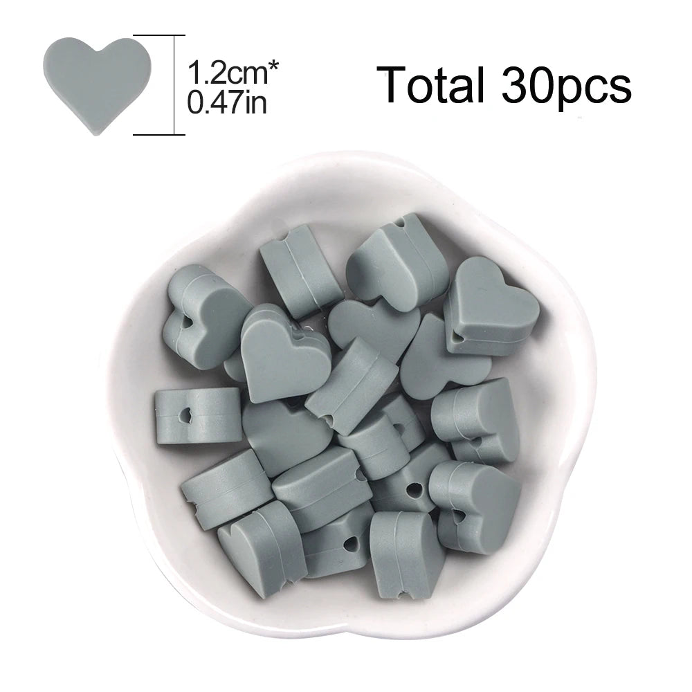A pile of 30 small, gray silicone heart beads for DIY jewelry making.