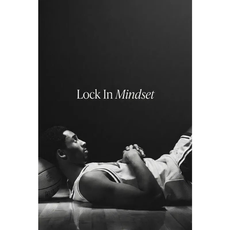 Black and white photo of a man resting his head on his hands in a basketball uniform, with the text Lock In Mindset above him