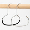 A silver circle ring hat hanger is shown hanging from a wooden rod.