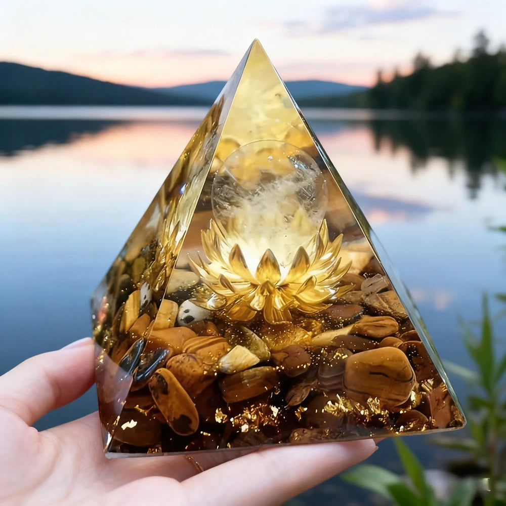 Handheld resin pyramid featuring natural obsidian stones and a glowing copper coil set against a lake background.