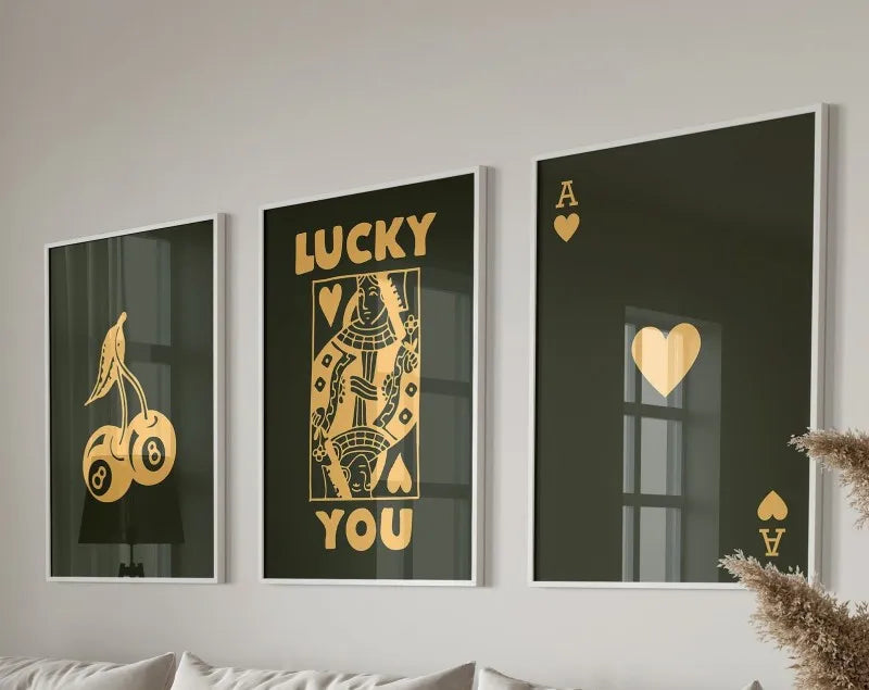 Three framed canvas prints featuring the text LUCKY YOU in gold lettering on dark backgrounds with heart and ace of spades mo