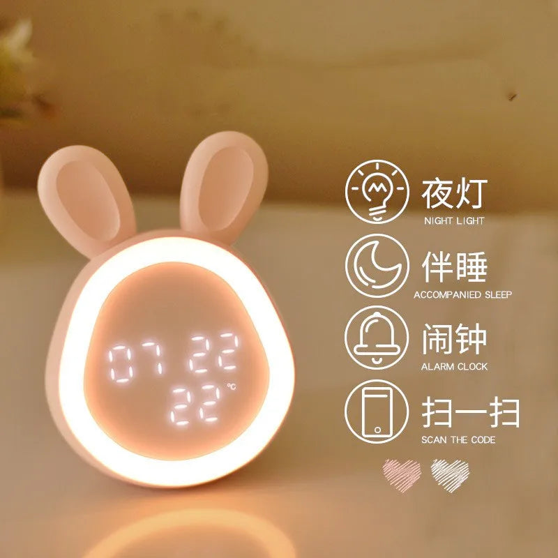 A pink, bunny-shaped LED night light and alarm clock device with a glowing face display.